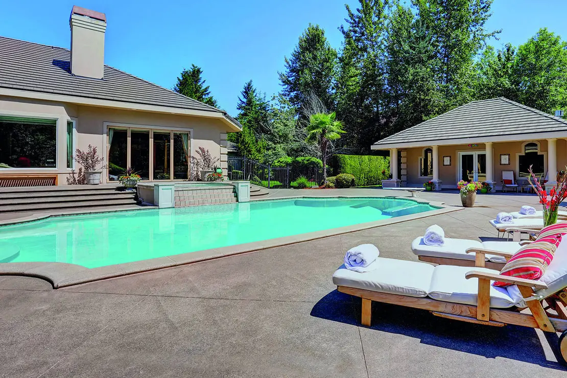 Casa con impresionante piscina pavimentada con hormigón impreso.